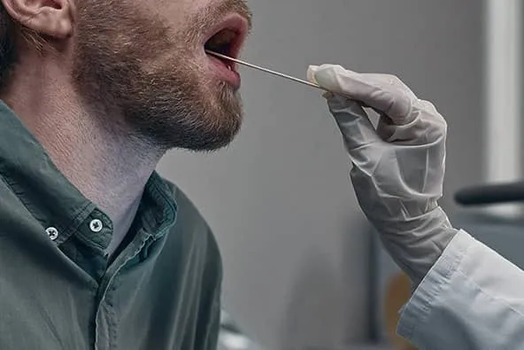 Homem realizando o teste de saliva.